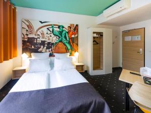 莱比锡莱比锡市住宿加早餐旅馆的卧室配有一张大床,墙上挂有绘画作品