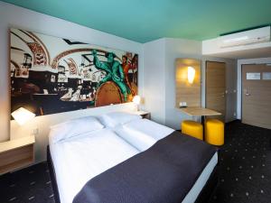 莱比锡莱比锡市住宿加早餐旅馆的卧室配有一张床,墙上挂有绘画作品