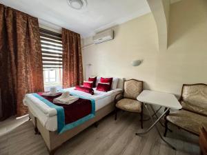 伊斯坦布尔Happy Suite Boutique Hotel的一间卧室配有一张带红色枕头的床和一把椅子
