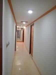 阿格拉Hotel Swarajya Palace的一条有白色墙壁的走廊和一个带门的走廊