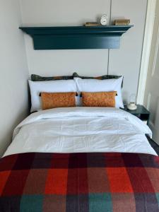 FodryLoop Head Lighthouse Attendant's Cottage的一间卧室配有一张带多彩毯子的床