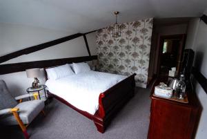 ThursleyHigh Barn的一间卧室配有一张床、一张沙发和一把椅子