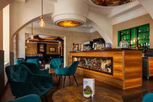 格拉茨Best Western Hotel Strasser的一间设有蓝色椅子的餐厅和一间酒吧