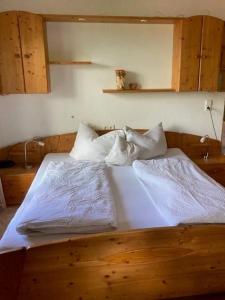 海因岑贝格布拉瑟霍夫旅馆的一间卧室配有带白色床单和枕头的床。