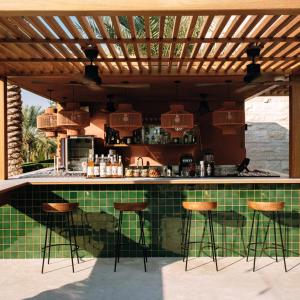 迪拜Meliá Desert Palm Member of Meliá Collection的一个带凳子和台面的户外厨房
