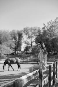 迪拜Meliá Desert Palm Member of Meliá Collection的站在围栏上看着马的女人