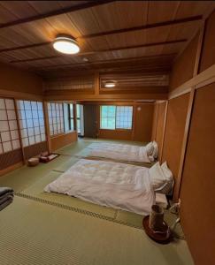 中津川市GUESTHOUSE YANAGIYA的一间位于中间的大型客房,配有两张床