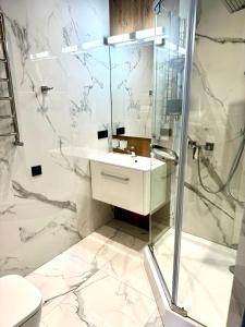 伊万诺-弗兰科夫斯克Miracle Place的带淋浴和盥洗盆的白色浴室