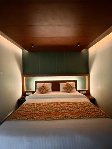 乌提Hotel City Palace的一间卧室配有一张大床和绿色床头板
