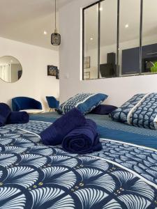 Cosy Appart’ & spa - Appartement privatif - baignoire balnéothérapie的客房内的两张床和蓝色枕头