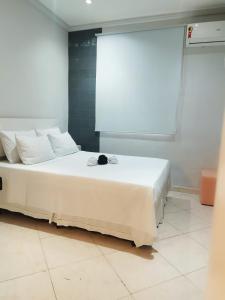 里约热内卢Quitinete ACONCHEGANTE的窗户客房内的一张白色床