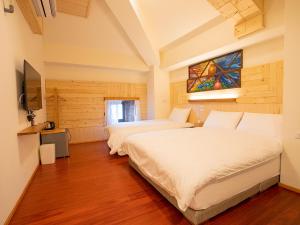 北竿芹壁休闲渡假村的一间卧室设有两张床和彩色玻璃窗。