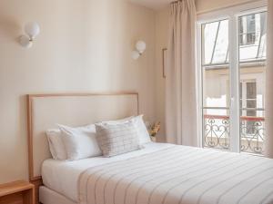巴黎巴斯酒店的白色的卧室设有床和窗户