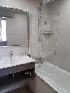 巴黎哈维酒店的白色的浴室设有水槽和淋浴。