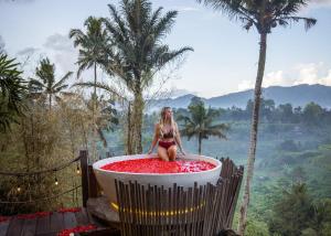 SelatCamaya Bali - Magical Bamboo Houses的坐在浴缸里的比基尼女人