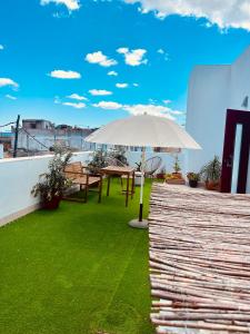 圣玛丽亚港Loft céntrico con gran terraza的屋顶上带桌子和遮阳伞的天井