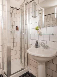 巴黎巴斯酒店的白色的浴室设有水槽和淋浴。