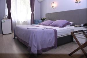 安卡拉A Hotels & Suite的一间卧室配有一张大床、紫色毯子和枕头