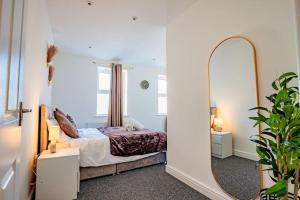 伦敦Guest Homes - Lewisham Flat的一间卧室配有一张床和镜子