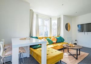 伦敦Guest Homes - Lewisham Flat的客厅配有黄色的沙发和桌子