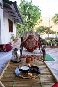 奈尼塔尔Nature's Vibe Homestay - Nainital - Kainchi Dham的桌子上放着一盘食物的桌子