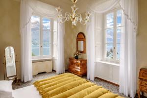 贝拉吉奥Grand Hotel Villa Serbelloni - A Legendary Hotel的一间卧室设有一张大床和两个窗户。