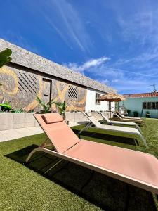 劳林哈Casas Jeronimos的草坪上一排躺椅和遮阳伞