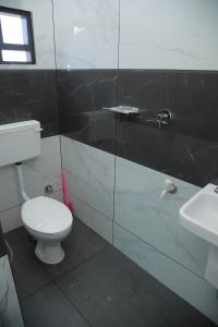 马拉普兰Thekkumpuram Tourist Home的浴室配有白色卫生间和盥洗盆。