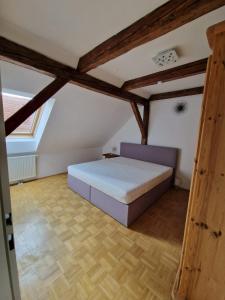 弗龙莱腾Casa di Giovanni - Österreich的阁楼设有1间带1张床的卧室,配有木梁