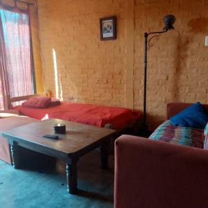 德尔迪阿布罗角Posada Mar Azul con Jacuzzi的客房设有两张床、一张桌子和一张沙发。