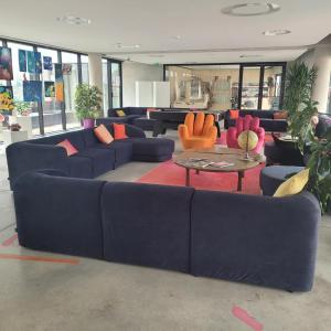 卡奥尔Auberge de Jeunesse HI Cahors的客厅配有蓝色沙发和橙色椅子
