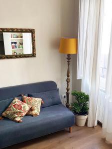 佛罗伦萨拉托雷农家乐的客厅配有带两个枕头的蓝色沙发