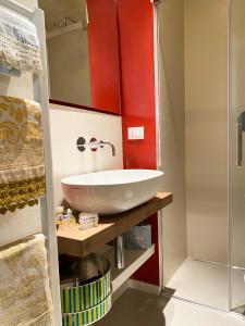 佛罗伦萨拉托雷农家乐的浴室设有白色水槽和红色的墙壁。