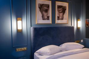 伊西翁L Suites The Writer's House的一间卧室,卧室的蓝色墙壁上挂着一张床铺上的图片
