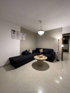 安曼Stylish Luxe Apartment的客厅配有黑色沙发和桌子