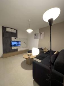 安曼Stylish Luxe Apartment的客厅配有黑色沙发和桌子