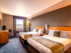 伦敦德里城市酒店的酒店客房设有两张床和窗户。