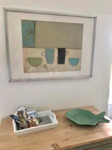 GratotLa Maison du Hommeel的一张桌子上放着照片,上面放着一条绿色的鱼