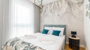 詹塔尔Apartamenty Sun & Snow Resort Jantar的一间卧室配有带白色床单和蓝色枕头的床。