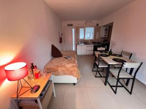 乌斯怀亚Bahía Golondrina 2的一间卧室配有一张床铺和一张桌子,还设有一间厨房