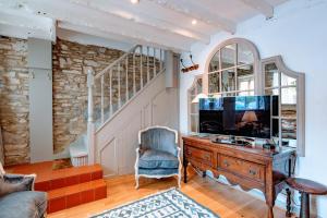 斯沃尼奇Cosy Little Hyde Cottage, Swanage的客厅配有电视、椅子和书桌