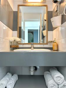 大博格Bungalow La Kawannaise - Piscine, Terrasse, Plage的浴室配有盥洗盆、镜子和毛巾