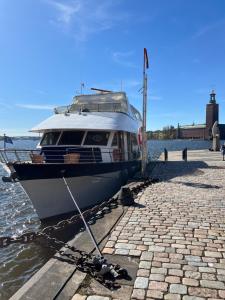 斯德哥尔摩Mälardrottningen Yacht Hotel的船被绑在码头上