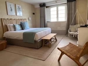 阿尔卜Ogygia Suites Gozo的卧室配有1张床、1张桌子和1把椅子