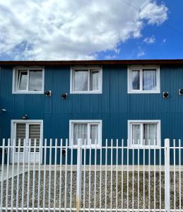 乌斯怀亚Bahía Golondrina 2的前面有白色围栏的蓝色房子