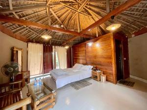 斯里曼加尔乌帕齐拉Tilagaon Eco Village的一间卧室设有一张床和木制天花板