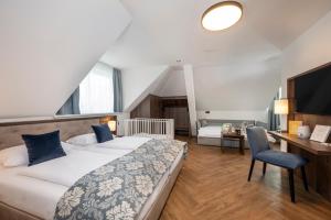 萨尔茨堡Salzburg Hotel Lilienhof的一间卧室配有一张床、一张桌子和一把椅子