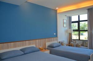 金城金门沐风民宿 的一间卧室设有两张床和蓝色的墙壁