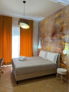 那不勒斯Le Corti del Re的一间卧室配有一张橙色墙壁的床