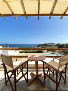 梅加斯·亚洛斯-奈特斯Agnadi Syros Beachfront Studios & Rooms的美景庭院设有两把椅子和一张桌子